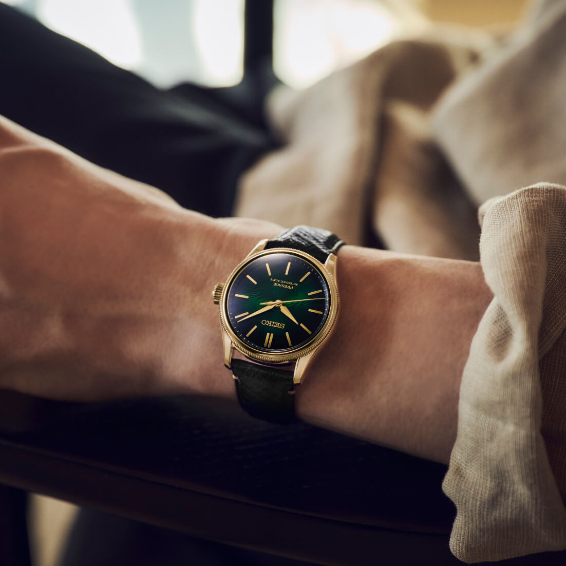 Seiko Presage HCC009J1 official seated wrist image showing gold bracelet and green dial